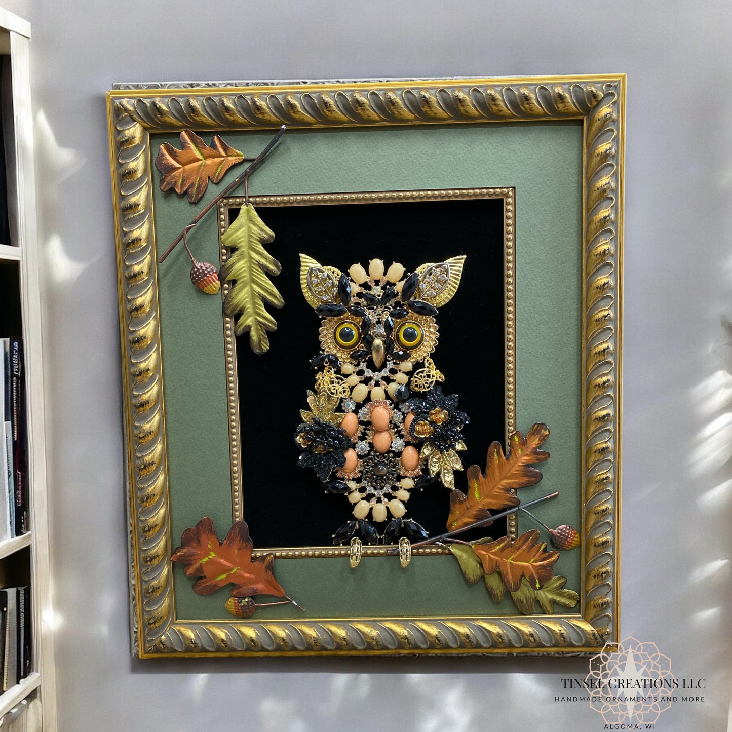 Decorative framed artwork of an owl with autumn leaves on a wall.