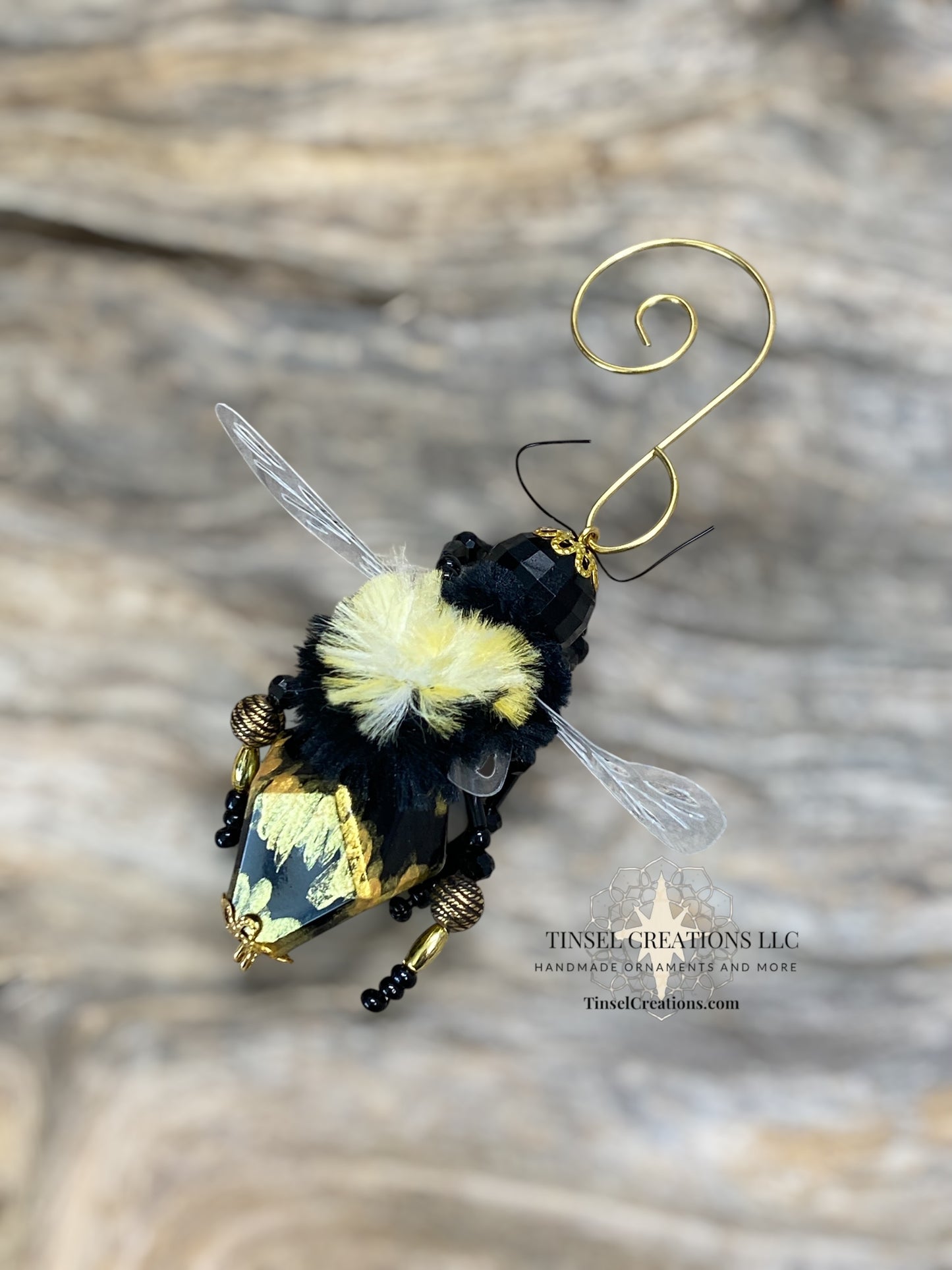 Decorative bee ornament with gold accents on a wooden surface