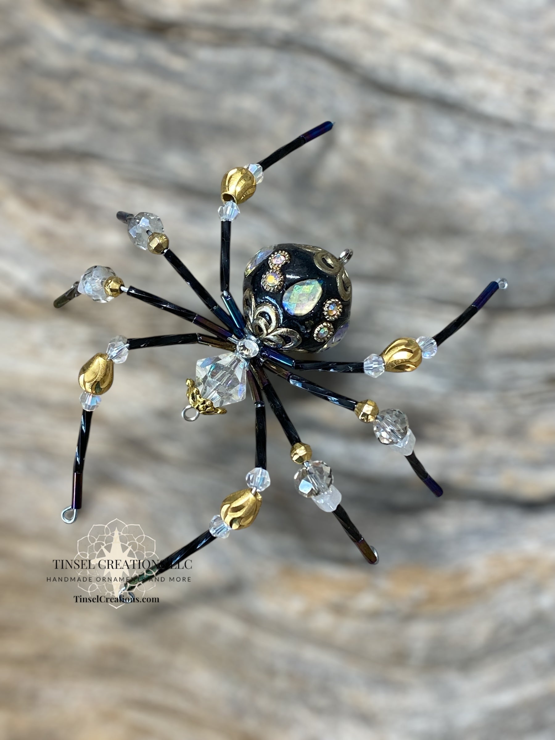 Decorative spider ornament with beads on a textured surface
