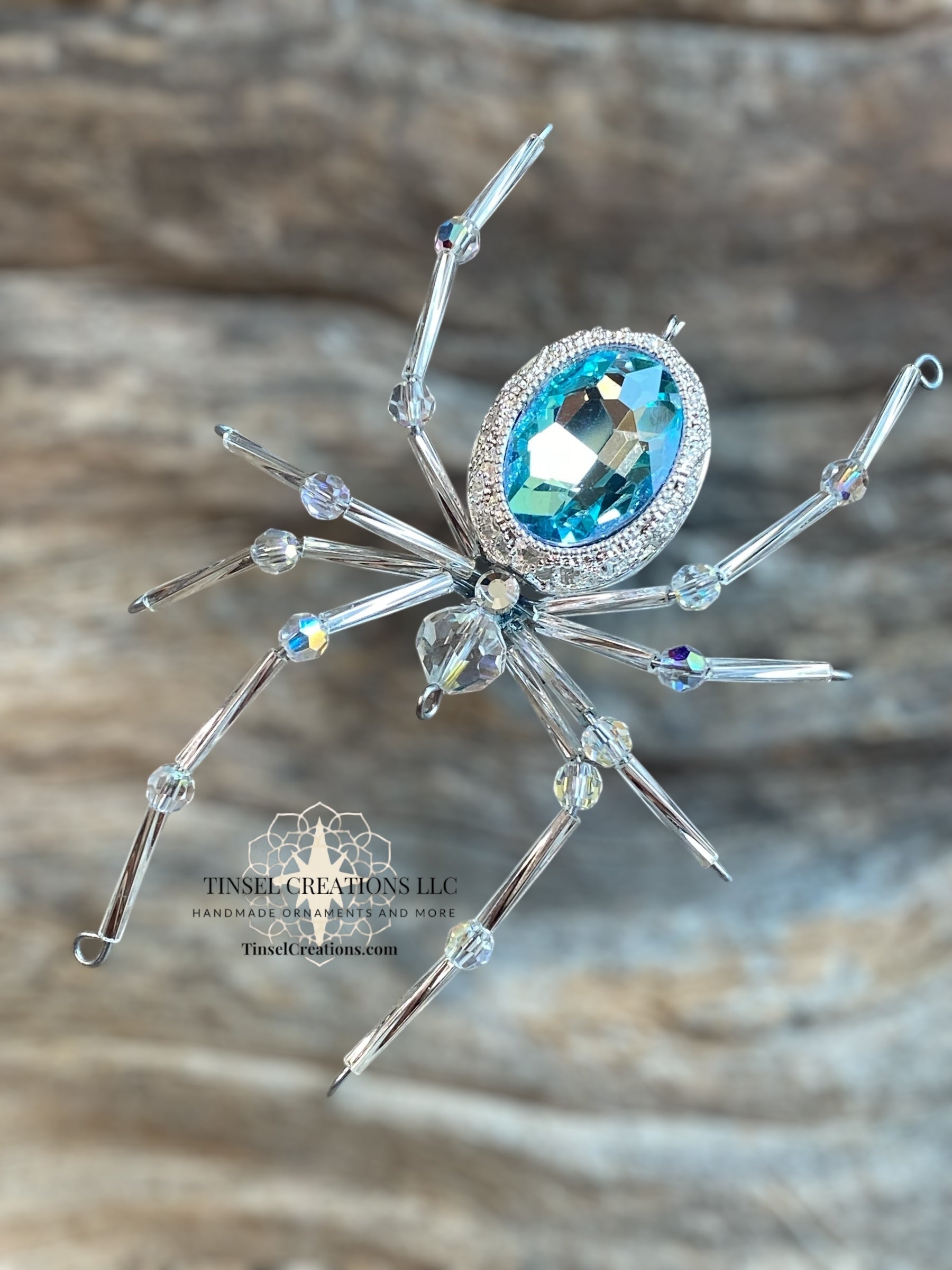 Decorative spider ornament with blue gemstone on a wooden background