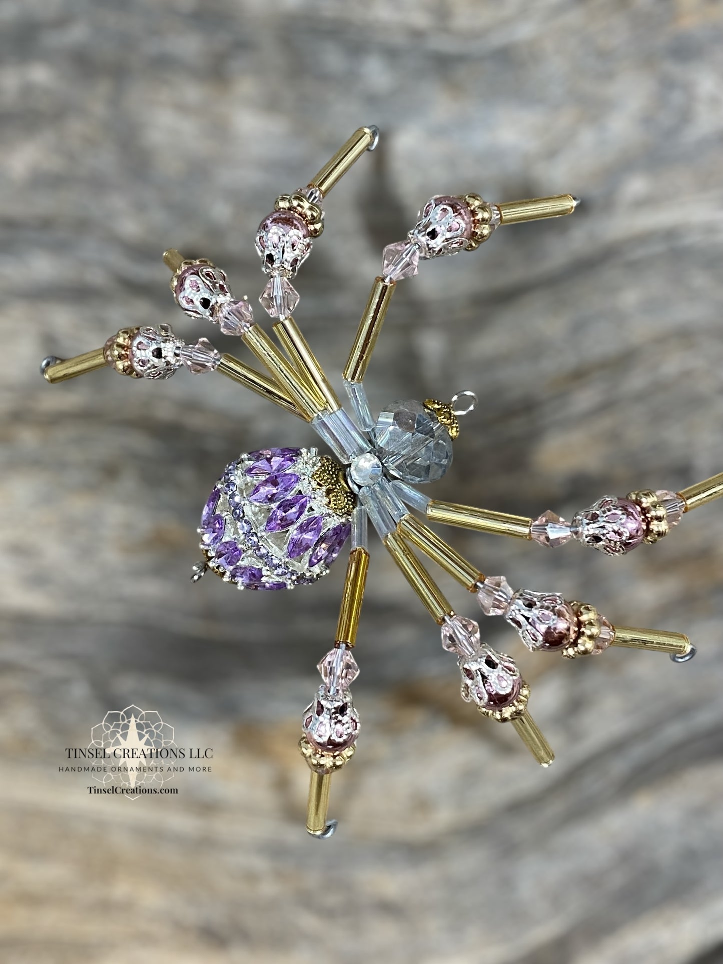 Decorative spider with gemstones on a textured gray background