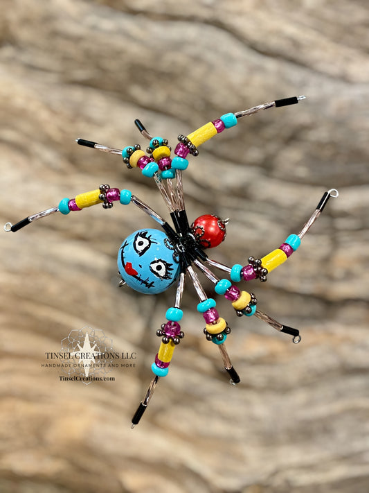 Colorful beaded spider sculpture on a wooden surface