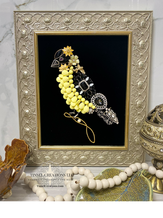 Decorative framed artwork of a bird with beads on a marble surface
